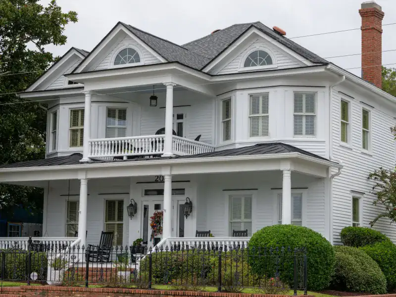 White two-story McKinney home with porches after a re-roof and new gutters